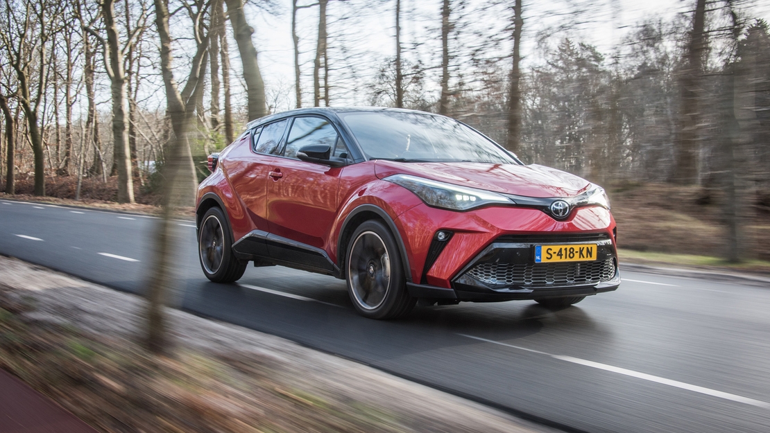 Toyota-C-HR-exterieur-rechts-voor-rood-rijdend-bos